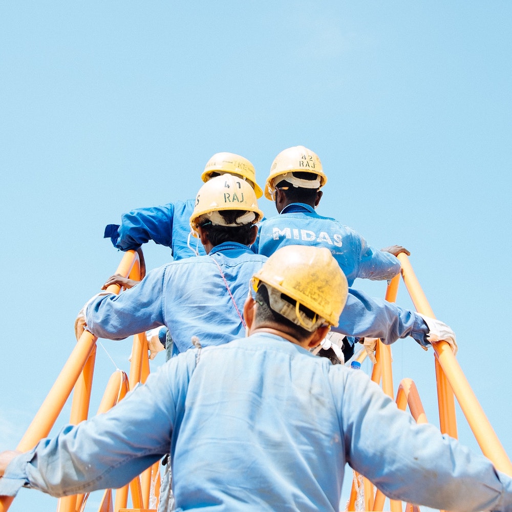 Groupe de travailleurs avec des combinaisons bleues et des casques jaunes de sécurité